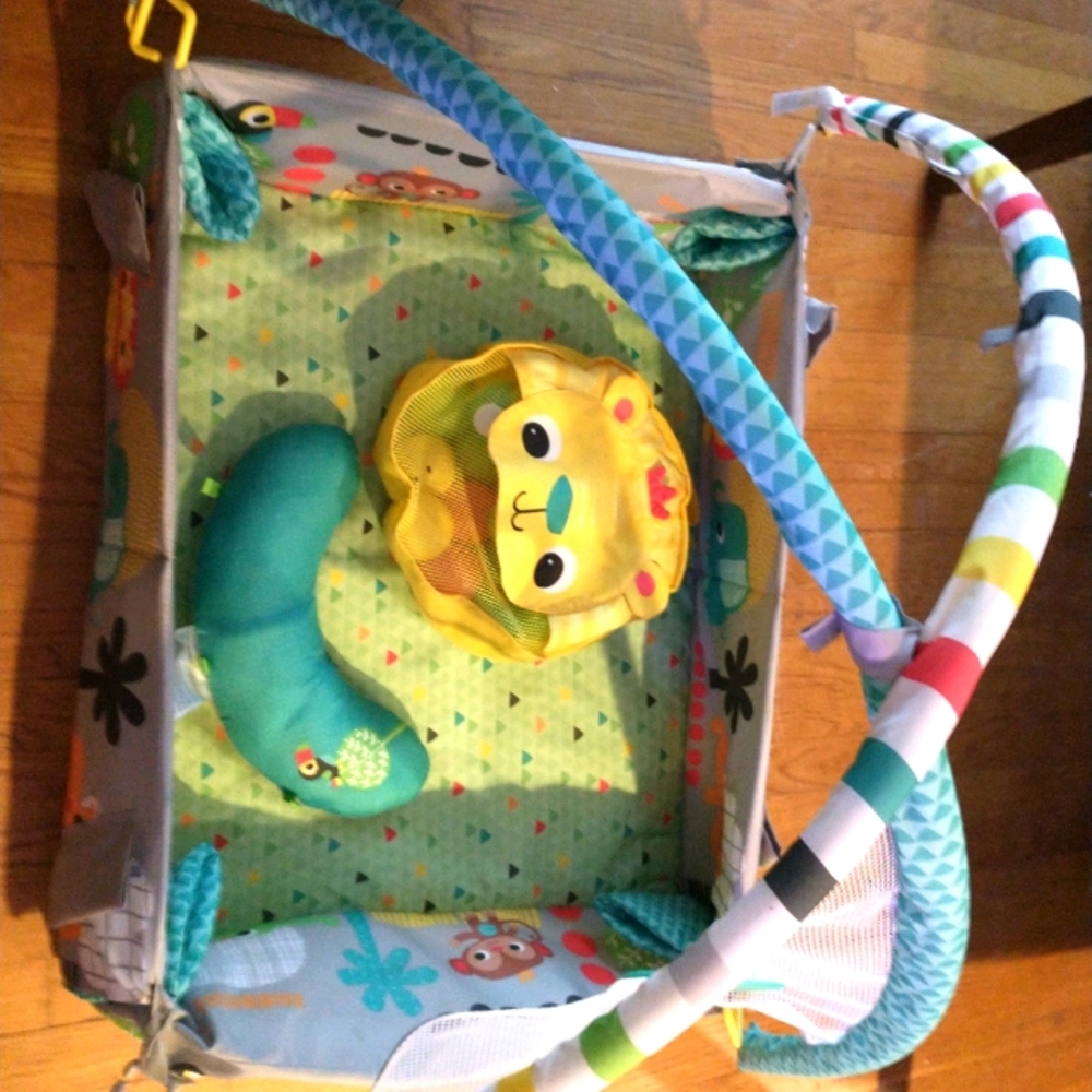 Baby play matt with hanging toys and bag of balls.